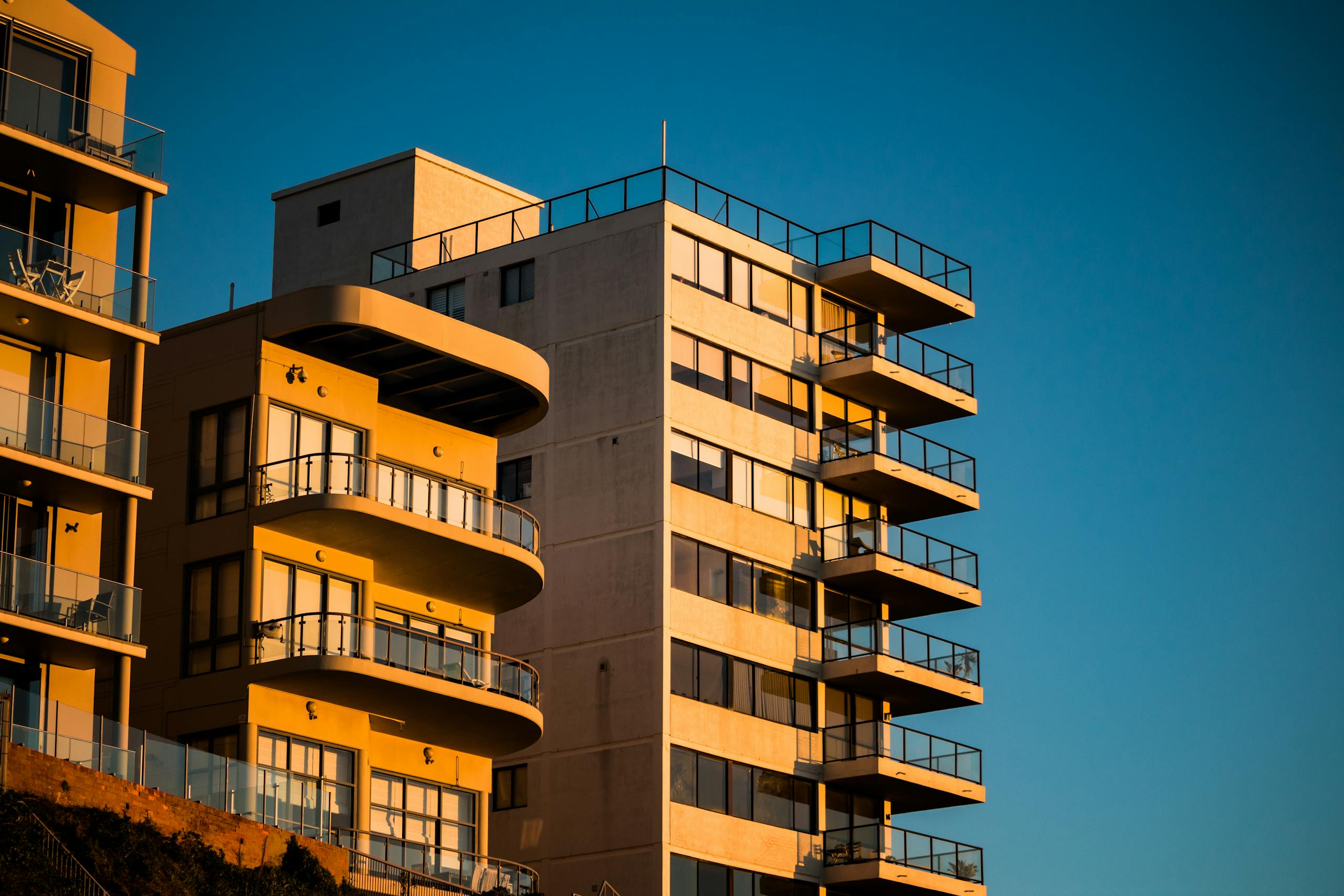 Modern apartment buildings with unique facades illuminated by sunset lighting.
