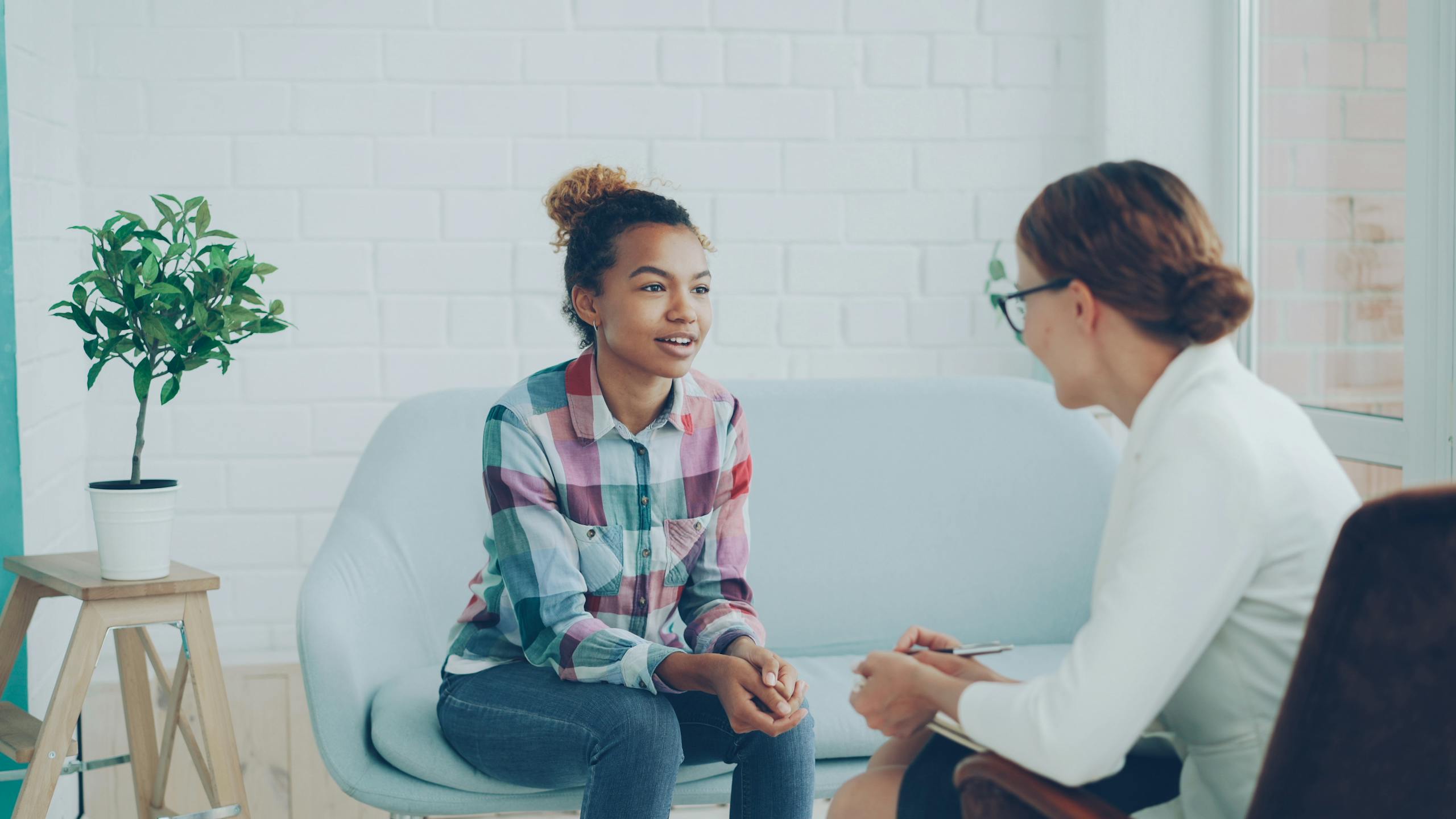 Teenager and therapist in a calm counseling environment.